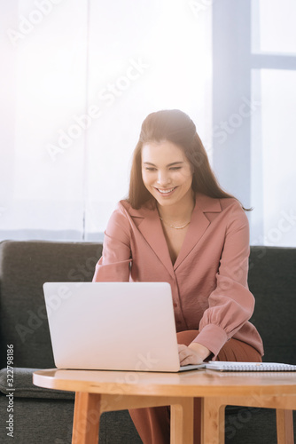 Obraz na plátne Beautiful smiling businesswoman ordering delivery with laptop at table