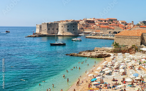 Fototapeta Naklejka Na Ścianę i Meble -  People on beach and Dubrovnik fortress in Adriatic Sea