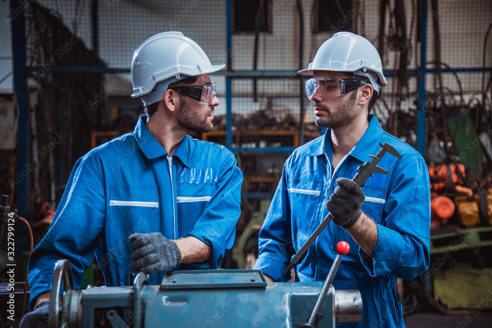 The Industry engineering wearing safety uniform used Vernier caliper to measure the object control operating machine working in industry factory The Industry engineering wearing safety uniform used Vernier caliper to measure the object control operating machine working in industry factory