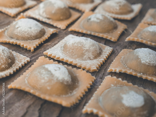 homemade ravioli on rustic wooden background