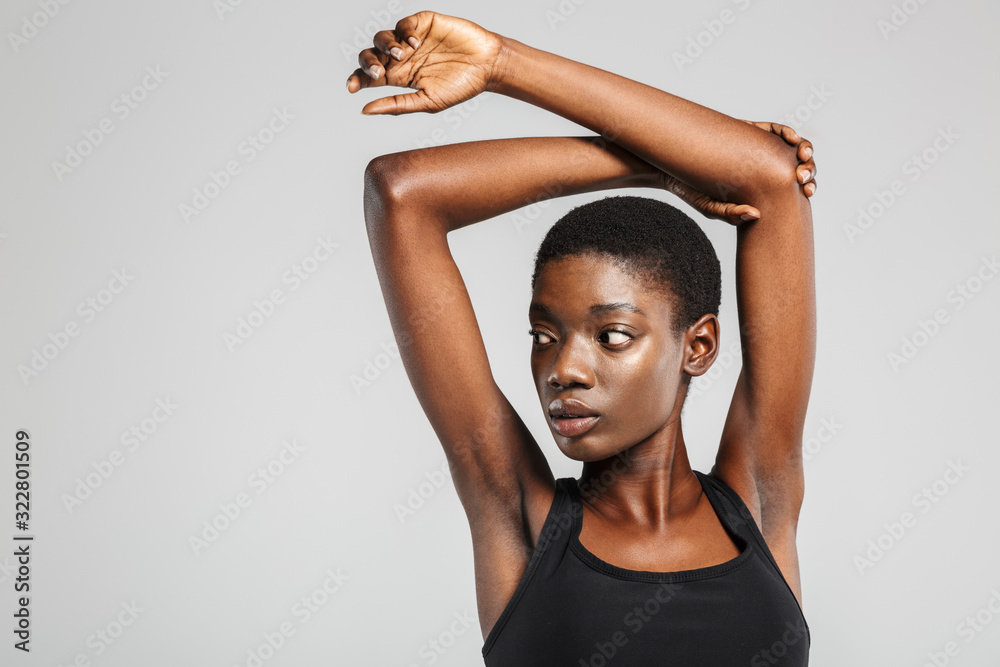 Fototapeta premium Image of athletic african american woman stretching her arms