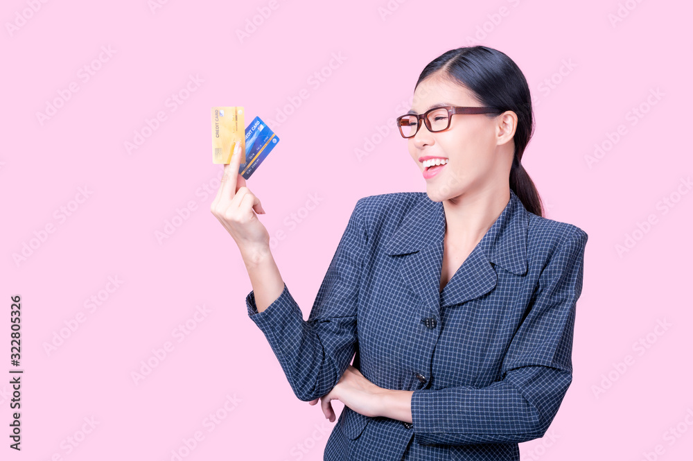 A beautiful Asian woman is happy and thinks that she will spend with many of her credit cards A beautiful Asian woman is happy and thinks that she will spend with many of her credit cards