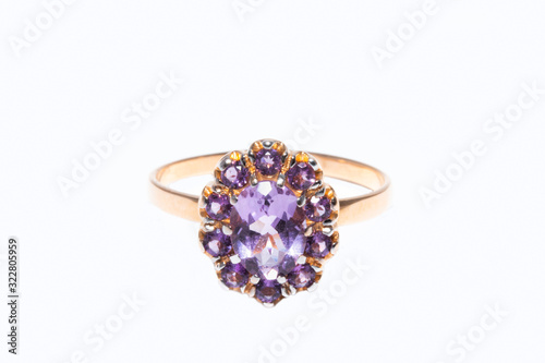 Beautiful golden ring with purple gemstone isolated on white background
