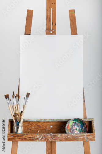 Wallpaper Mural Art painting easel with blank white canvas painters brushes and paint tools