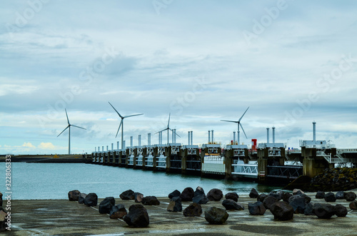 Oosterscheldekering, the Netherlands, August 2019. In Zeeland, wind farms are the setting for the immense dam that governs the flow of sea waters, securing the territory. photo