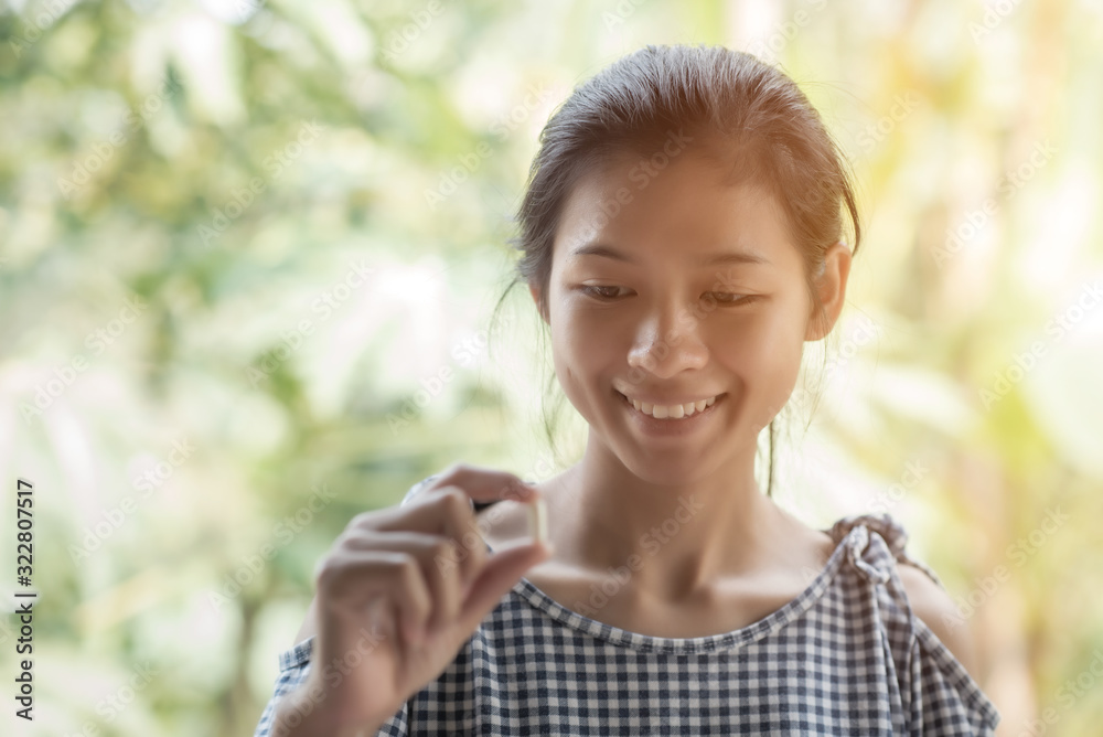 Young slim woman crazy lose weight diet pill in hands holding show to camera, looking to her hand and smile. Young slim woman crazy lose weight diet pill in hands holding show to camera, looking to her hand and smile.