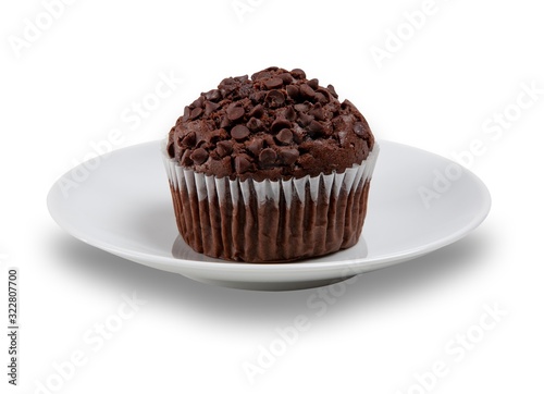 Chocolate muffin with choc chips on the top on a white plate  shot on a white background
