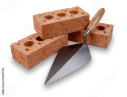 A set of house building bricks and trowel, isolated on a white background