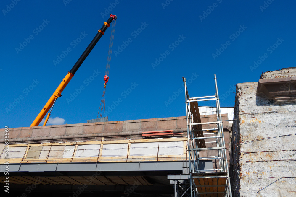 Naklejka premium Reconstruction of the Bolshoi Moskvoretsky Bridge, lifting crane with cargo.