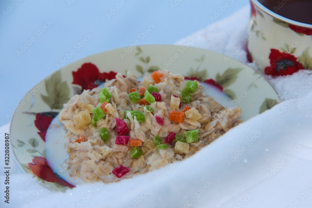 Oatmeal porridge with dried fruits with tea in the snow Oatmeal porridge with dried fruits with tea in the snow