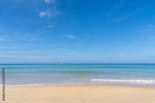 Ocean view and white sand beach with blue sky and a tiny wave background