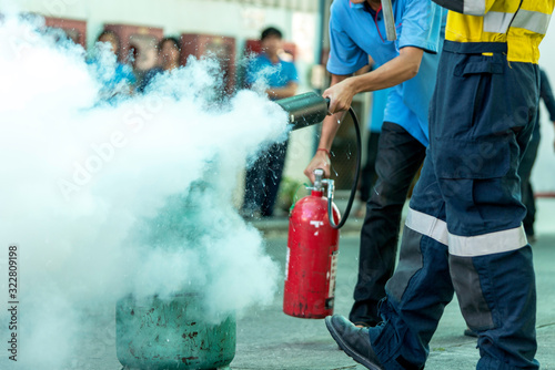 Man teaches how to use fire extinguisher to extinguish fire. photo
