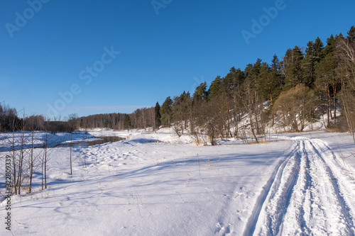 Landscape with a small river on a winter sunny day and blue sky, 02/08/2020, Ivanovo, Russia.