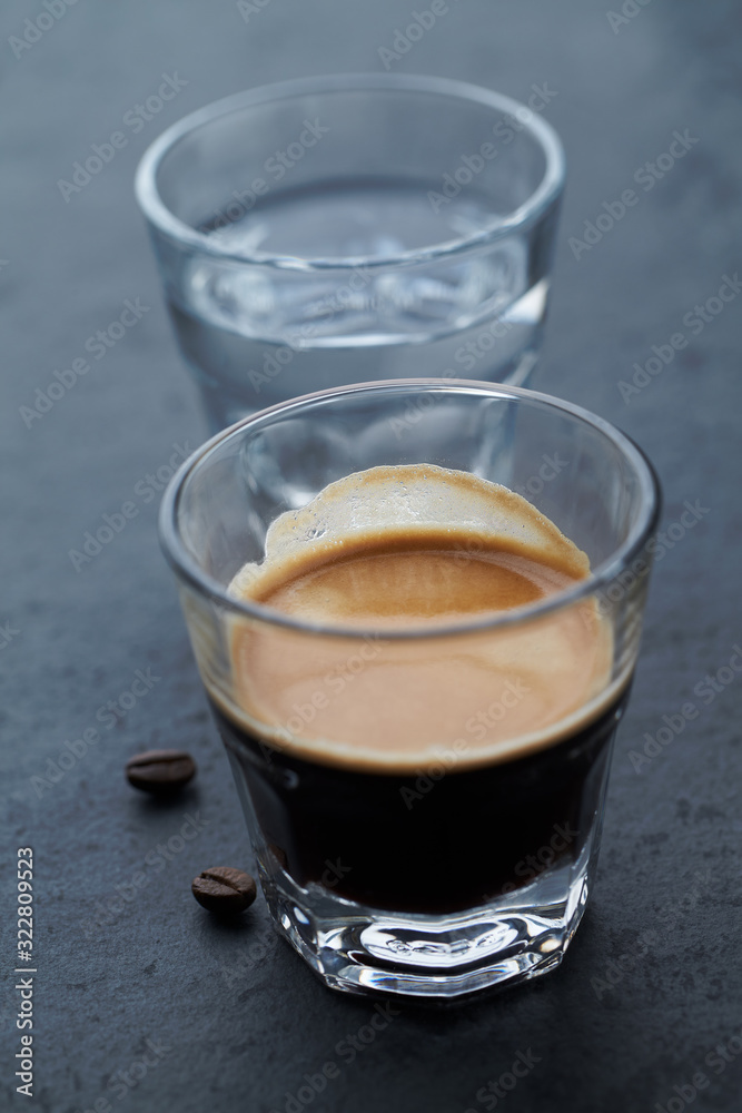Coffee in glass cup on dark stone background. Close up. Coffee in glass cup on dark stone background. Close up.