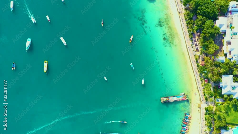 AERIAL Stunning shot of tropical island harbor on a refreshing tranquil morning. Moored boats and ferries wait for crowds of tourists to take them island hopping around the spectacular Phi Phi Islands AERIAL Stunning shot of tropical island harbor on a refreshing tranquil morning. Moored boats and ferries wait for crowds of tourists to take them island hopping around the spectacular Phi Phi Islands