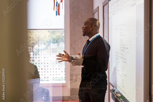 Male instructor leading lesson at projection screen in classroom photo