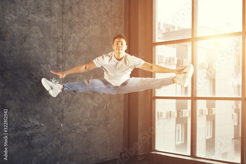 young attractive male dancer doing the splits in jump