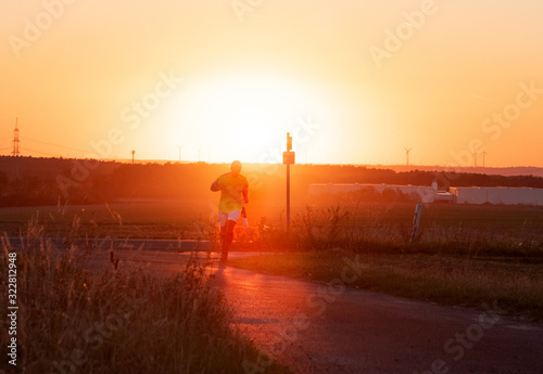 A man running in the golden mist of sunset.