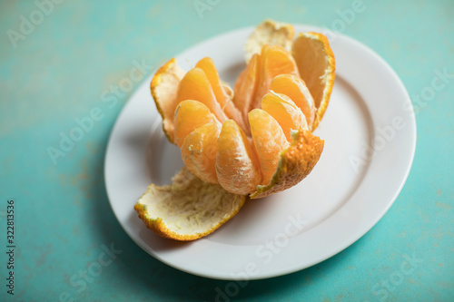 Pop of orange from this giant Sumo tangerine with the peel on blue-green flat lay from above