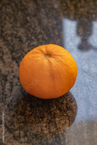 Orange on a kitchen marble with shadows
