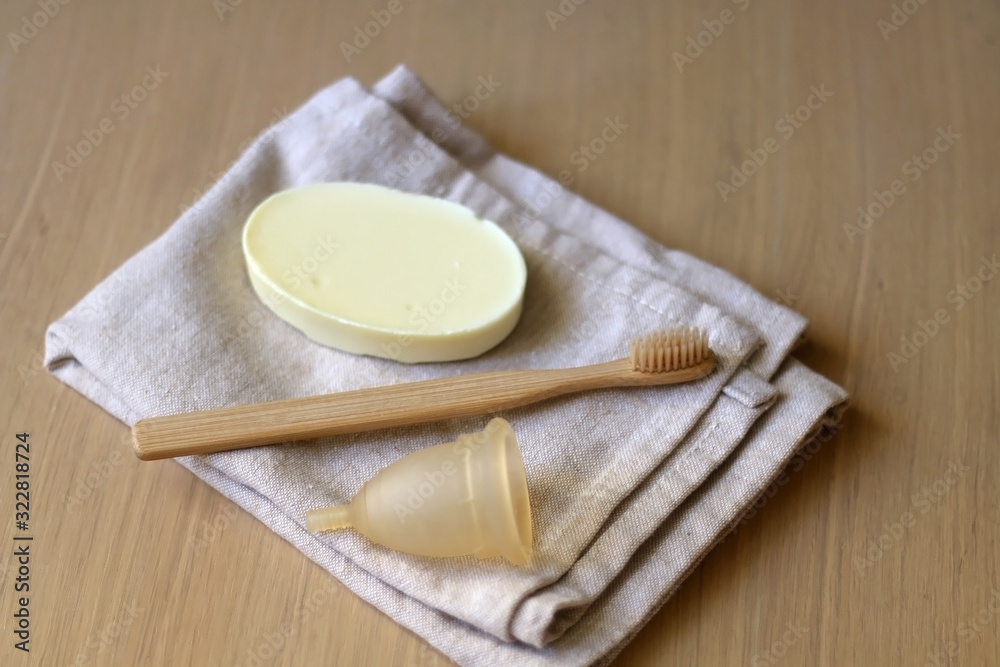 Linen cloth, soap, bamboo toothbrush and menstrual cup. Zero waste bathroom products. Selective focus.