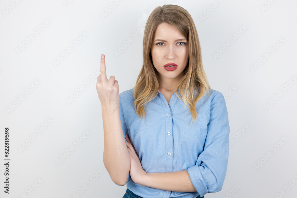 portrait of young blond brutal woman showing fuck off sign on isolated white background, body language portrait of young blond brutal woman showing fuck off sign on isolated white background, body language
