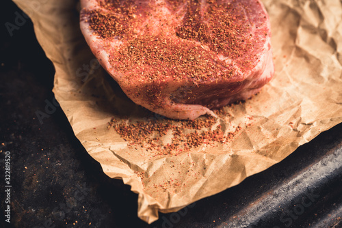 Raw fresh meat with spices on the rustic background. Selective focus. Shallow depth of field.