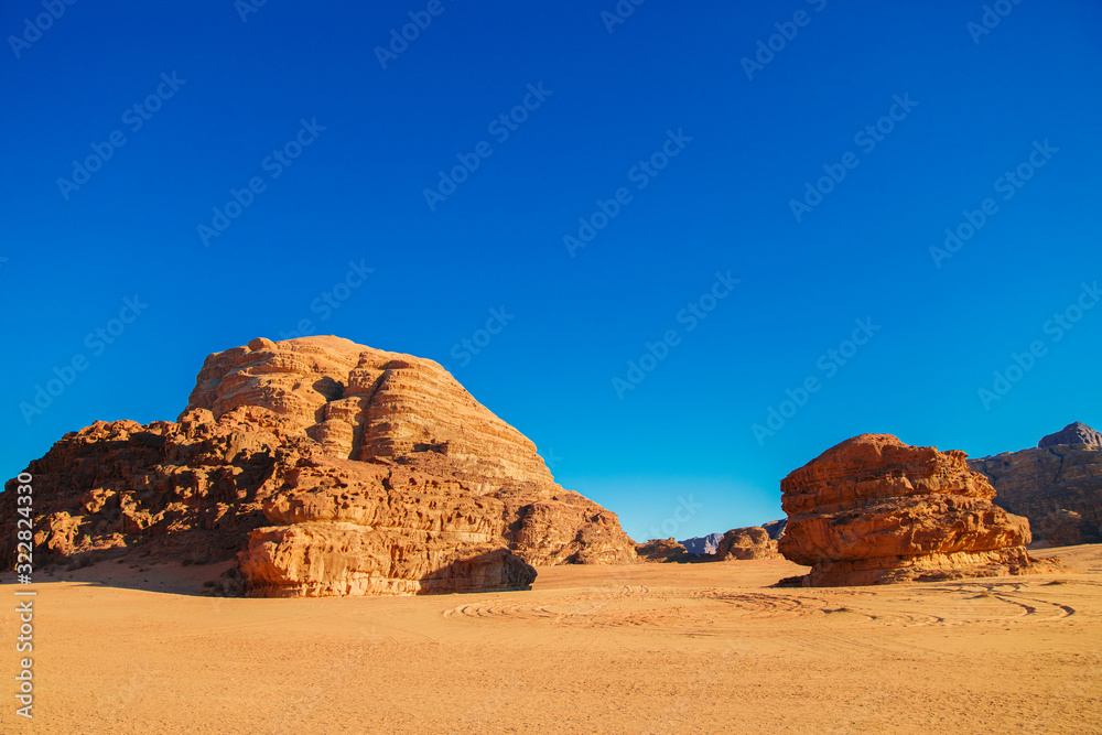 Textured sand mountains of red and orange sand against the blue sky, Jordan, Wadi Rum desert. Textured sand mountains of red and orange sand against the blue sky, Jordan, Wadi Rum desert.