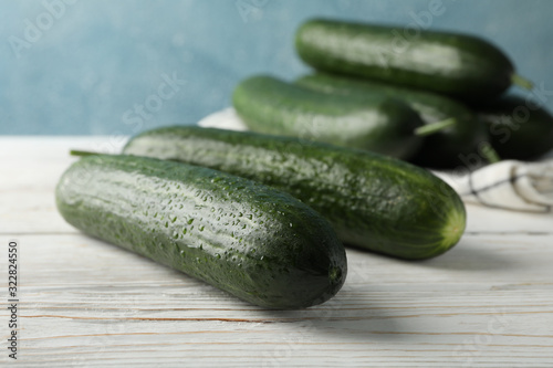 Cucumbers and towel on wooden background, close up
