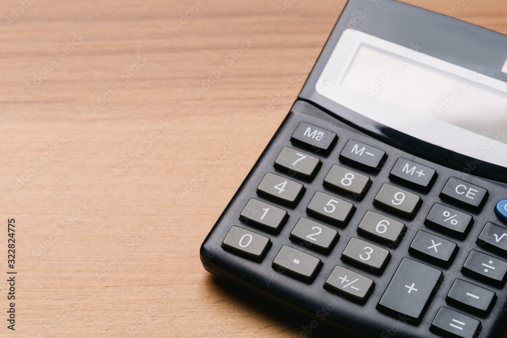 Modern calculator, Business and Finance accounting concept on wooden table Modern calculator, Business and Finance accounting concept on wooden table