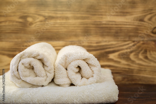 twisted towels on a wooden background copy the space. bath and shower accessories