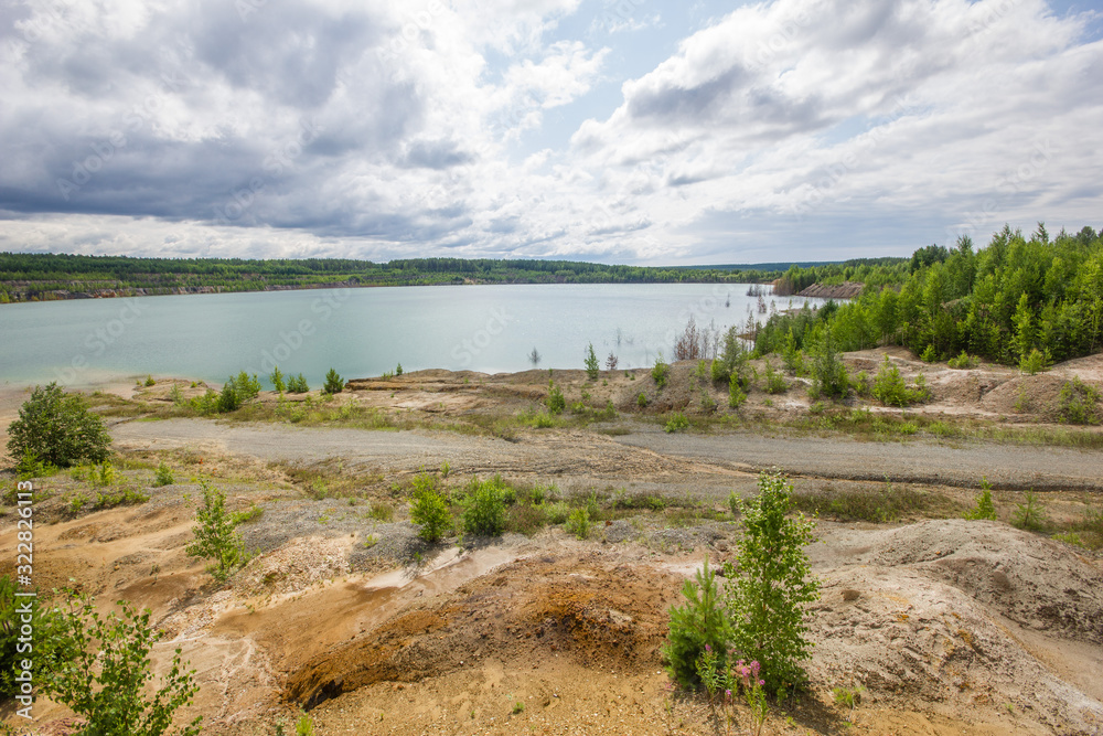 Flooded clay quarry lake with green water landscape