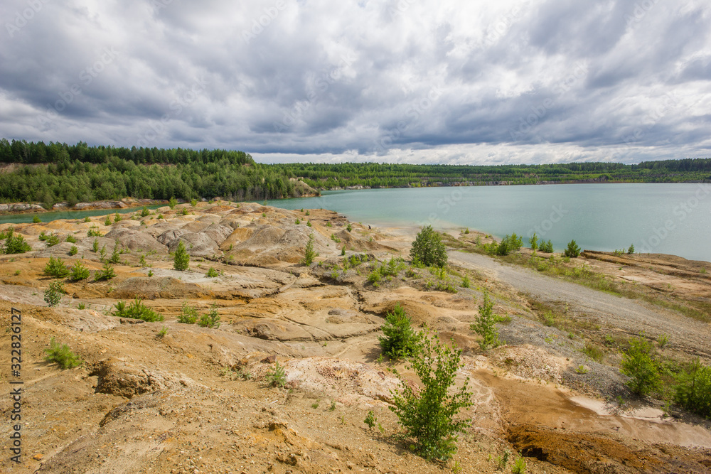 Flooded clay quarry lake with green water landscape