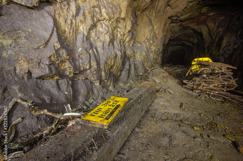 Old copper mine underground tunnel with yellow sign