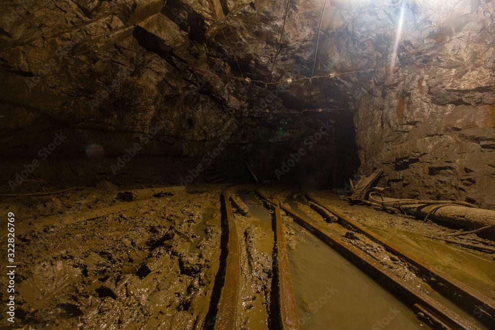 Naklejka premium Gold mine underground tunnel with rails