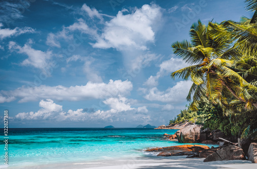 Fototapeta Naklejka Na Ścianę i Meble -  Perfect tropical tranquil beach. Pristine crystal clear ocean water with blue sky and white clouds. Summer time vacation and lifestyle