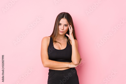 Young fitness caucasian woman isolated pointing temple with finger  thinking  focused on a task.