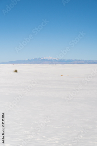 A snow capped mountain peak in the background of White Sands in New Mexico. 