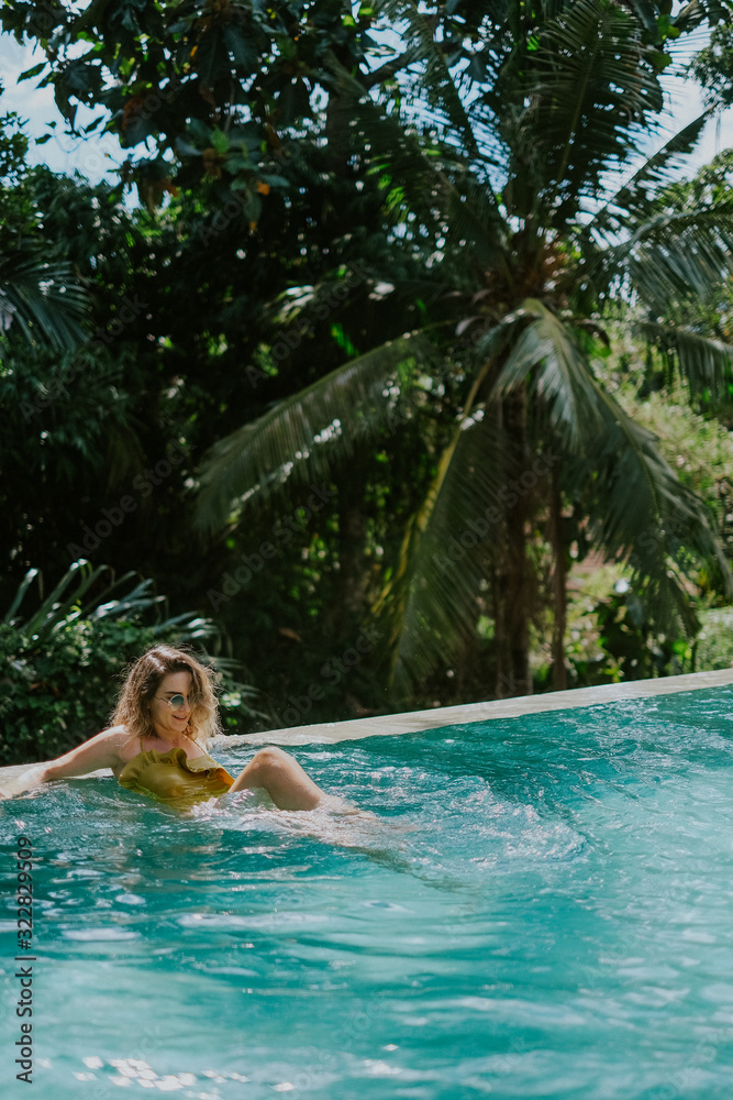 Young woman in infinity pool in the jungle in Ubud, Bali