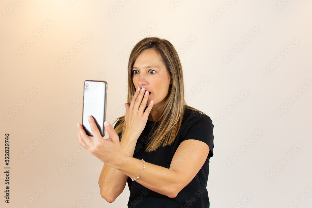 Young woman with mobile in hand surprised Young woman with mobile in hand surprised