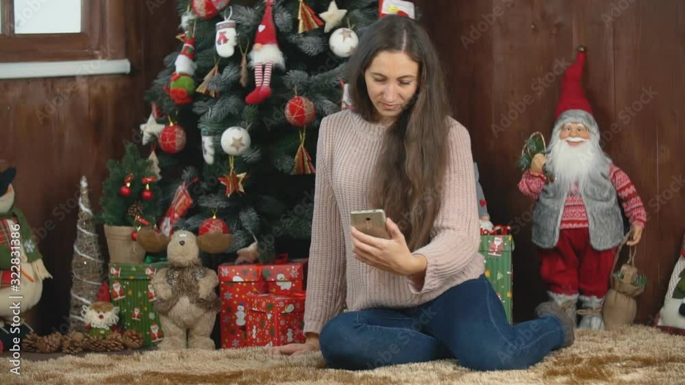 girl makes selfie while sitting near the Christmas tree girl makes selfie while sitting near the Christmas tree
