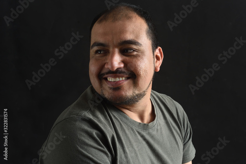 portrait of latin american man looking to the side on black