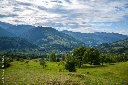 Beautiful panorama of the Carpathian village against backdrop of scenic mountains, where the highlanders live Hutsul. Wild forests, fields pastures, Ukraine 
