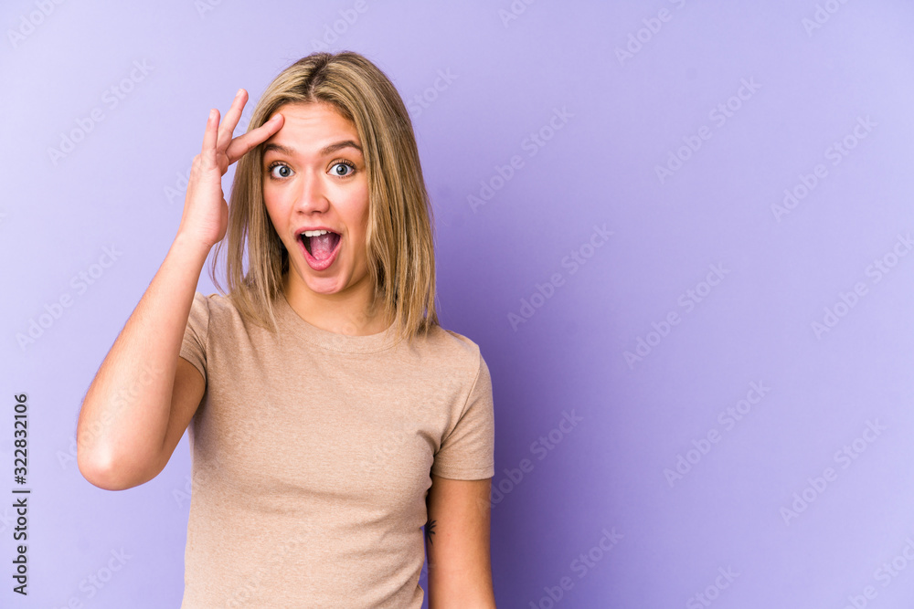 Young blonde caucasian woman isolated shouts loud, keeps eyes opened and hands tense.