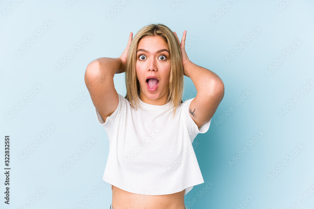 Young blonde caucasian woman isolated screaming, very excited, passionate, satisfied with something.