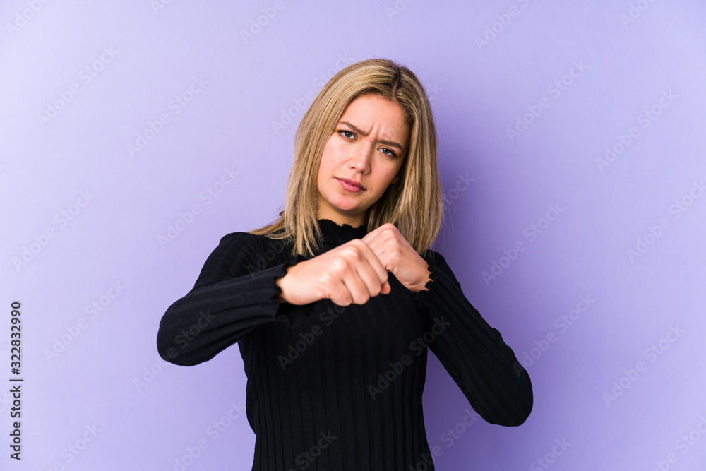 Young blonde caucasian woman isolated throwing a punch, anger, fighting due to an argument, boxing. Young blonde caucasian woman isolated throwing a punch, anger, fighting due to an argument, boxing.