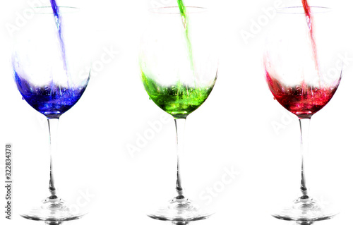Three glasses with colored liquids. Blue, green and red. The fluid flows into the glasses