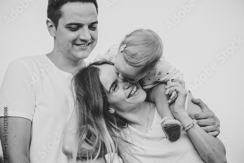 Bild auf Leinwand Portrait of a happy young family spending time together on nature, on vacation, outdoors