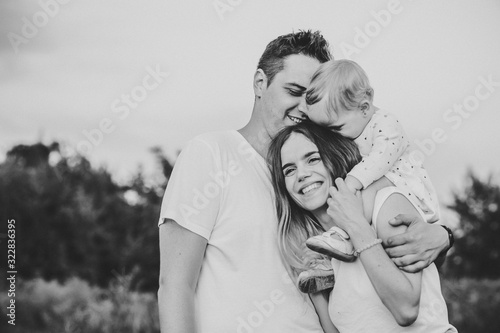 Foto Portrait of a happy young family spending time together on nature, on vacation, outdoors