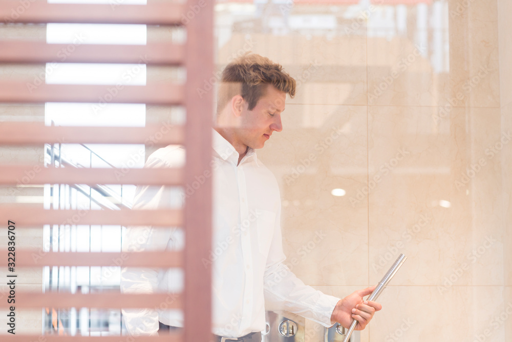 Salesman in a showroom showing a shower attachment, Germany Stock Photo